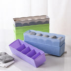 Close-up of a clear plastic storage organizer with various craft beads in sections.