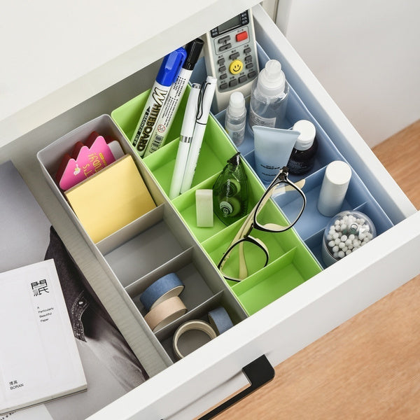 Clear plastic organizer box with sections holding colourful beads and craft supplies.