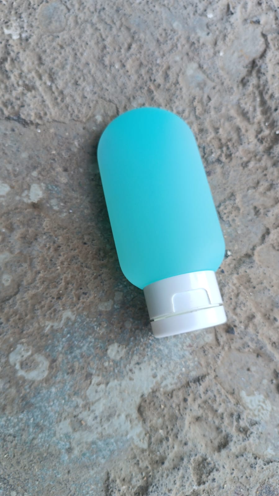 A single 60ml leakproof plastic travel bottle in a vibrant assorted color, ready for your next adventure.