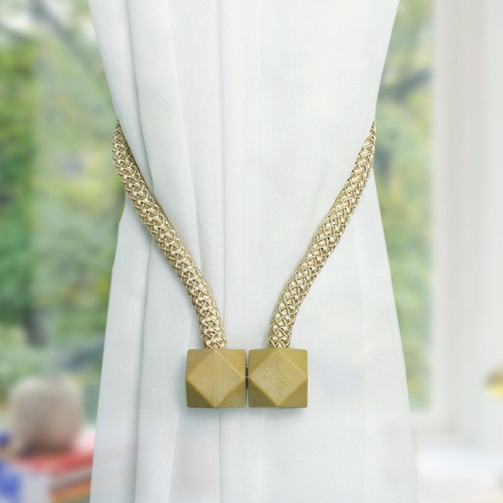 Stylish magnetic curtain tiebacks in a braided rope design, holding back a window curtain.