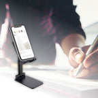 The foldable mobile stand in a compact state next to a phone.