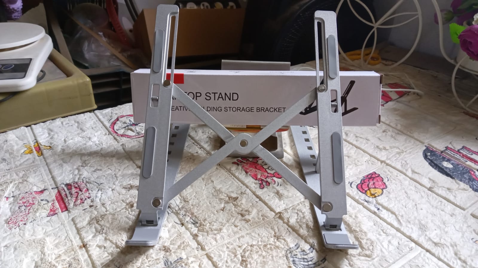 A person comfortably working at a desk with their laptop elevated on the portable stand.