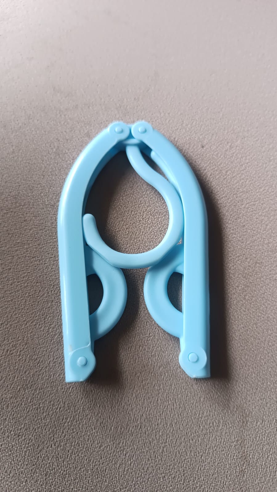 Single travel hanger shown in its fully compact, folded position for easy portability.