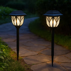 Two FitFuzion solar pathway lights illuminating a garden path with a unique water-ripple pattern at night.