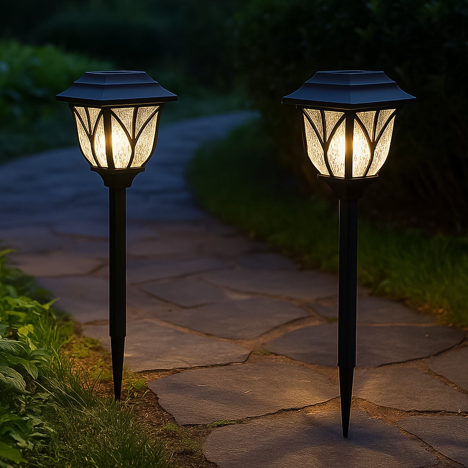 Two FitFuzion solar pathway lights illuminating a garden path with a unique water-ripple pattern at night.