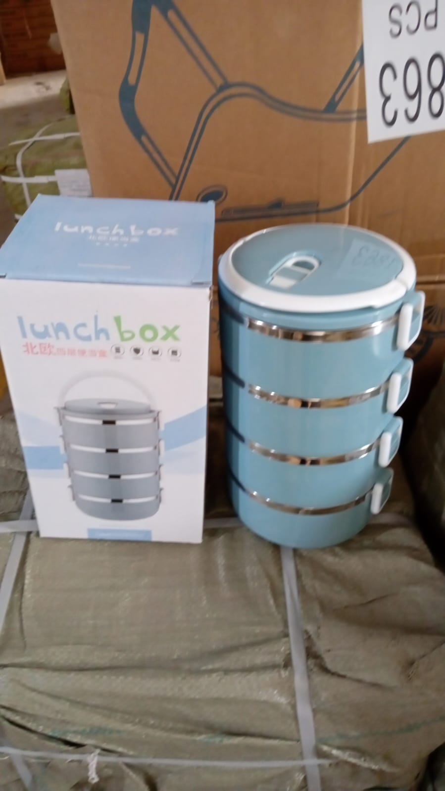 Ergonomic handle on a 4-layer stainless steel hot lunch box.