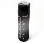 Person holding the sleek black motivational water bottle during a workout session.