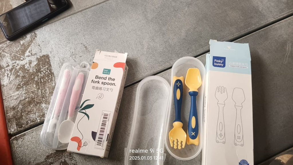 A child's hand comfortably gripping the ergonomic handle of a bendable toddler utensil.