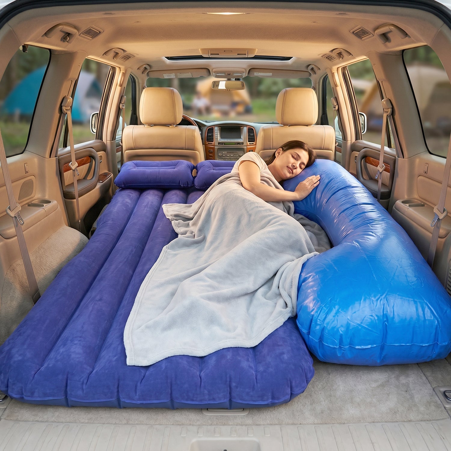 Couple relaxing on the inflatable car mattress inside SUV during camping trip