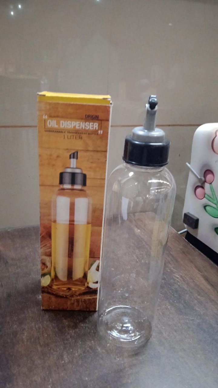 Hand holding the clear 1L oil dispenser, demonstrating its easy-pour function.