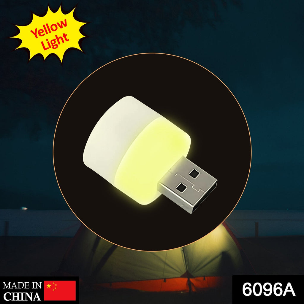 Portable yellow USB light bulb plugged into a laptop for office use.