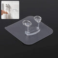Transparent self-adhesive wall hook mounted on a clean, smooth wall.