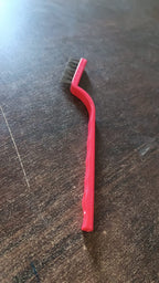 Person demonstrating the versatile use of the mini wire brush for detailed cleaning tasks.