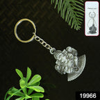 Person holding Lord Ganesha silver metal keychain in hand
