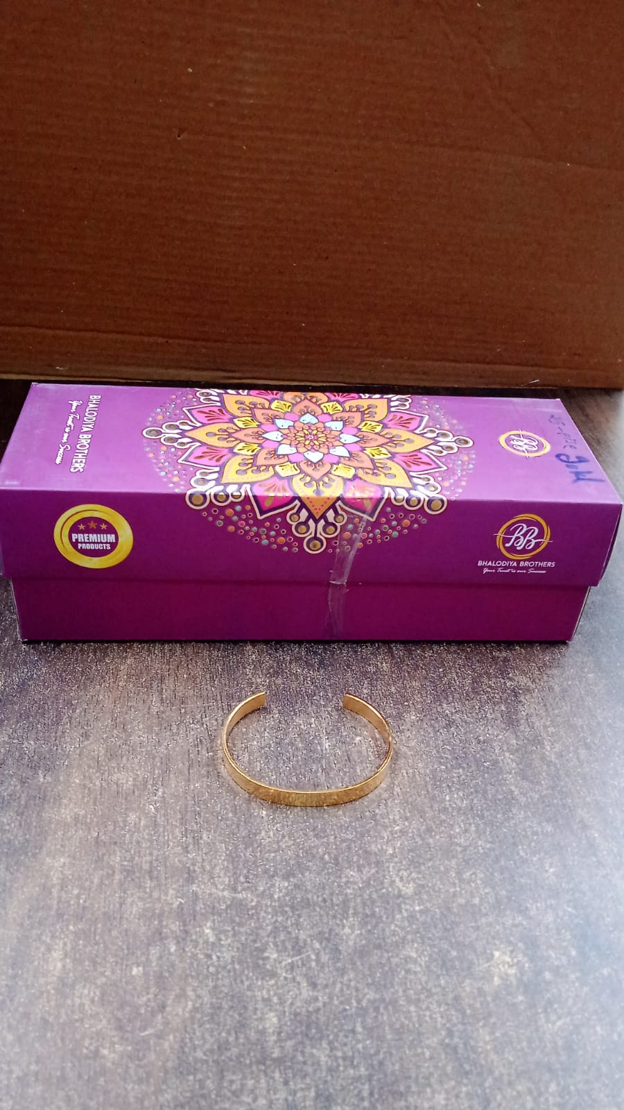 Close-up detail of gold finish open cuff bracelet Kada material and finish
