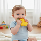 A happy baby holding and chewing on the ergonomic banana fruit teether, finding comfort.