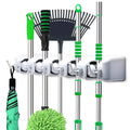 Wall mounted mop holder with 5 slots and 6 hooks for organized cleaning tools.
