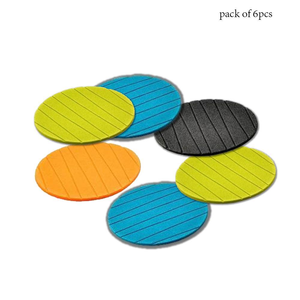 Assorted colourful round silicone cup mats displayed on a wooden surface.