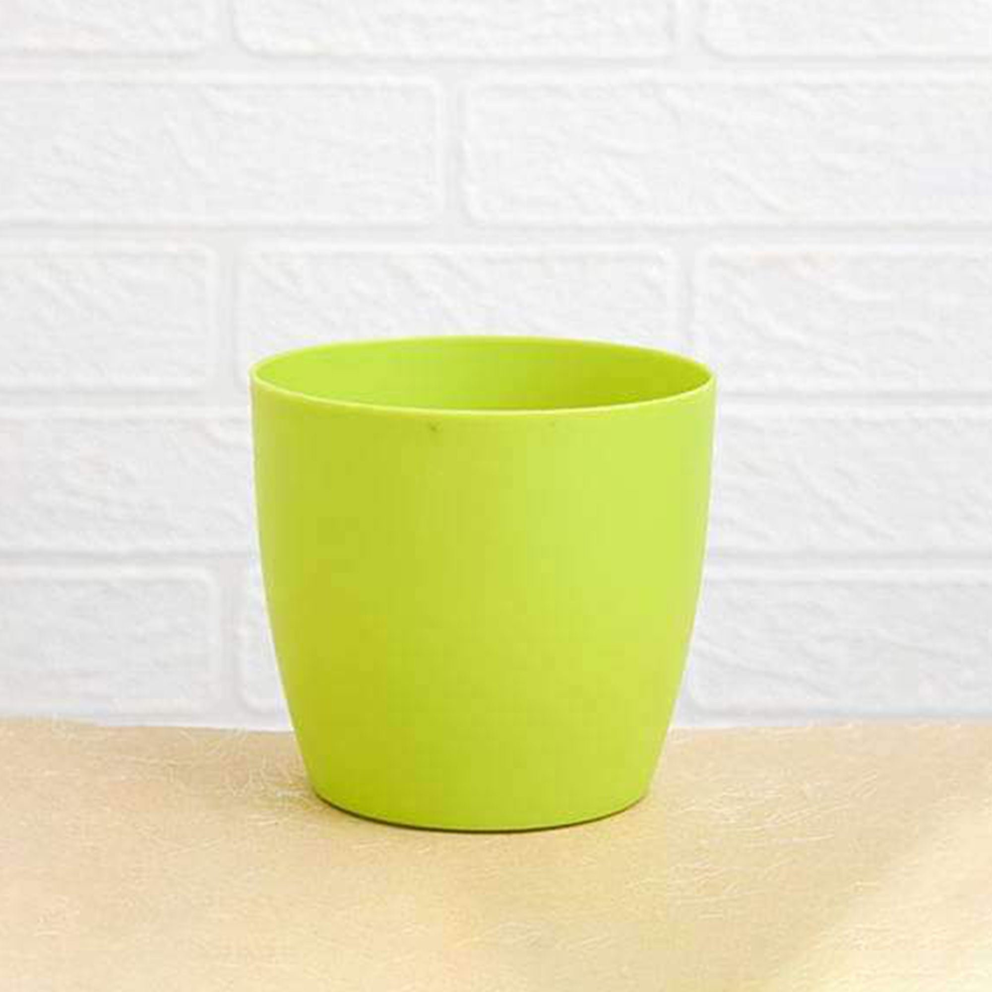 Round plastic flower pots displayed in a garden setting, suitable for all weather.