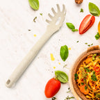 A black plastic pasta fork with serrated edges and a draining hole, ideal for serving spaghetti.