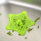 Star-shaped sink strainer in a kitchen sink, preventing clogs.