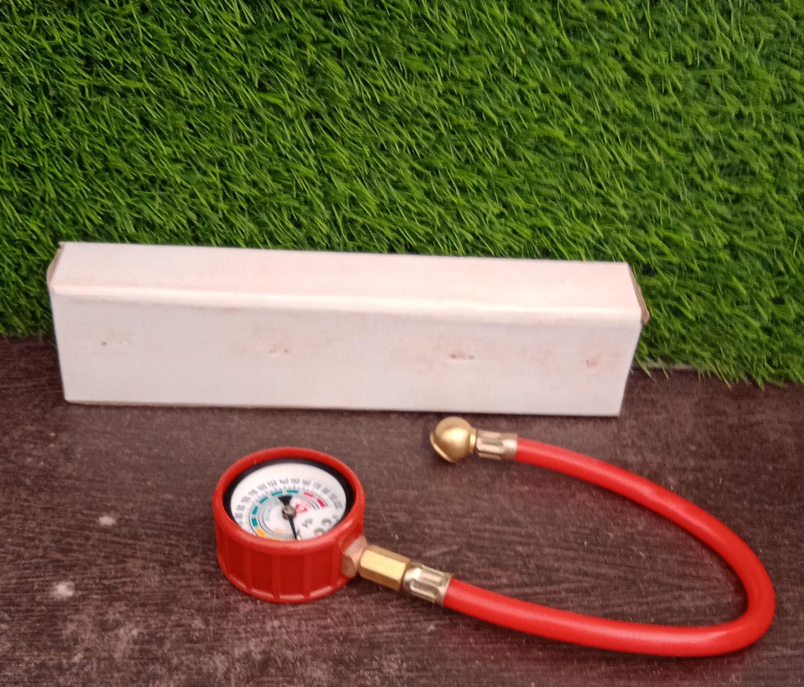 Analog tire inflator gauge clearly showing its PSI and kg/cm² measurement scales.