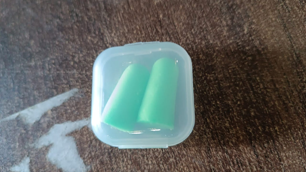 Person relaxing with soft foam earplugs in, enjoying peace and quiet.