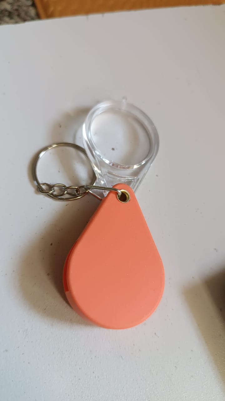 Magnifying glass keychain hanging from bag as portable magnifier