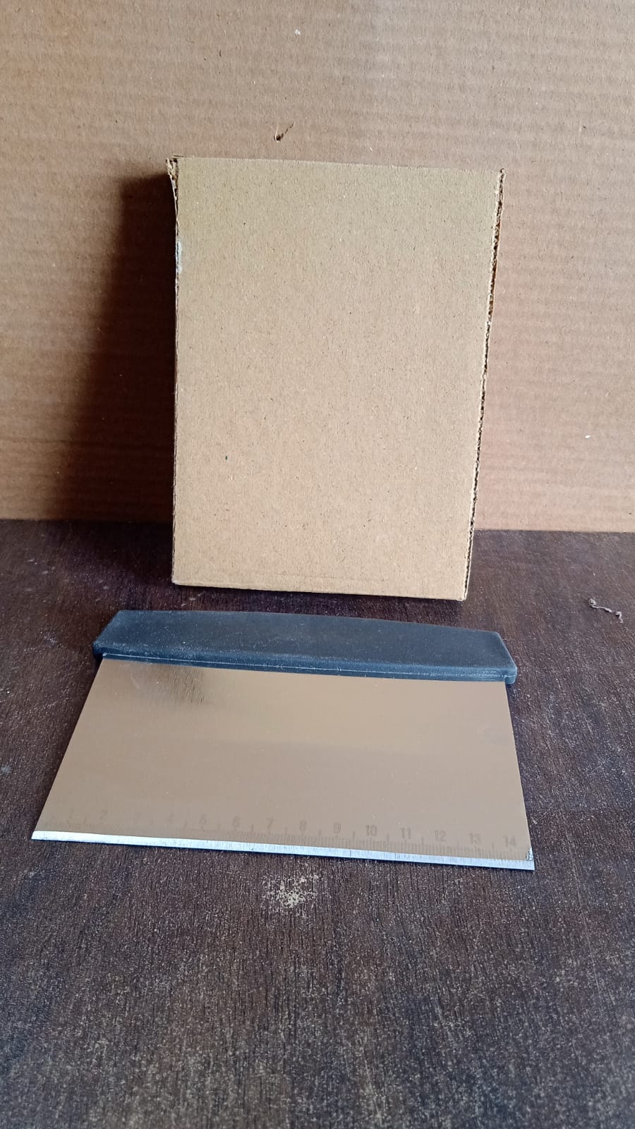 Dough scraper standing upright on kitchen counter ready for baking preparation