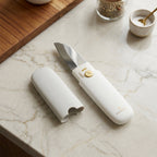 Stainless steel multifunctional peeler and knife tool, securely folded for storage.