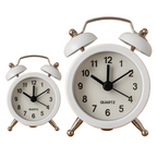 Vintage twin-bell analog alarm clock on a minimalist study desk.