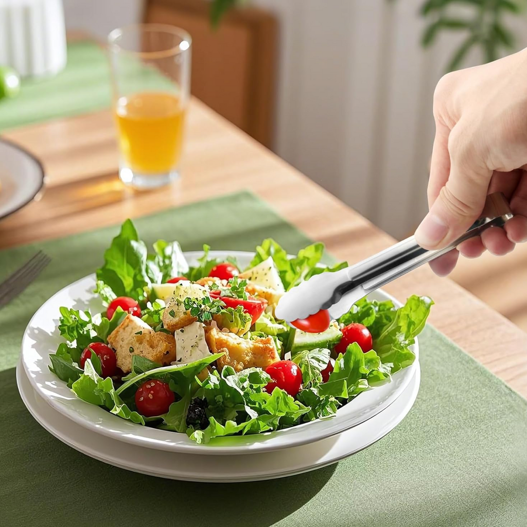 Ergonomic grip on stainless steel serving tong held in hand