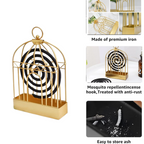A lit mosquito coil safely burning inside the decorative birdcage holder.