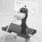 PHOBIA black multi-purpose wall mount stand holding a phone on a wall socket.