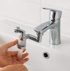 Woman using the rotating faucet sprayer to wash vegetables in a kitchen sink.