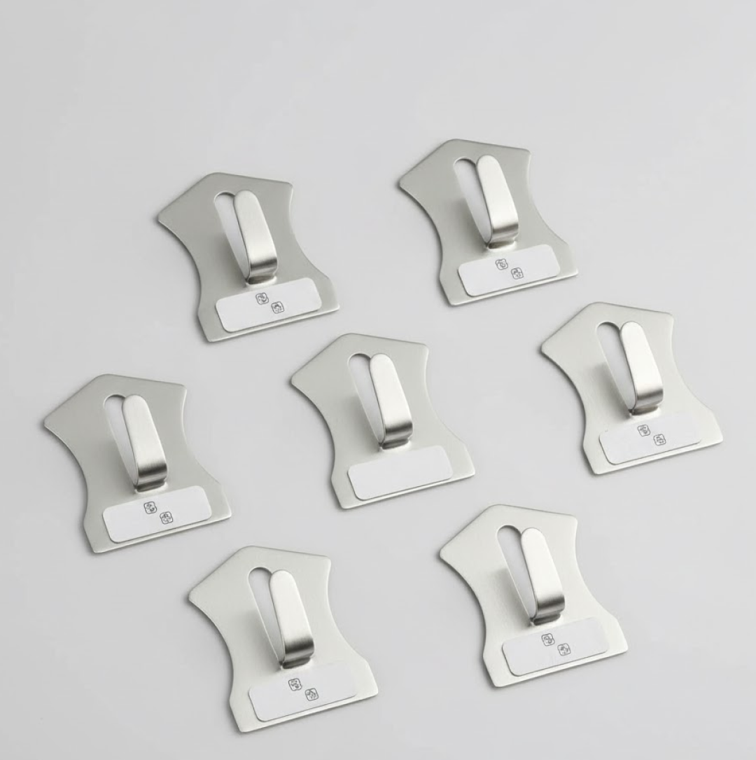 An 18-piece set of self-adhesive stainless steel wall hooks displayed on a white surface.