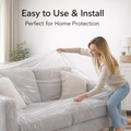 Person covering a beige sofa with a clear disposable furniture cover.