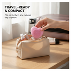 Ergonomic heart-shaped silicone face brush held in hand.