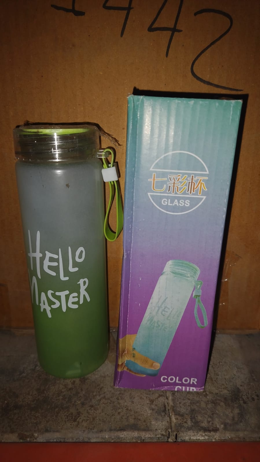 Front view of a glass water bottle showcasing its unique colorful motivational design.