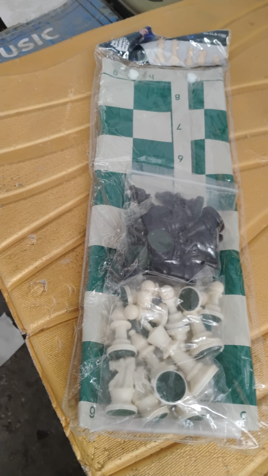 Portable chess set with foldable board and plastic pieces on flat surface