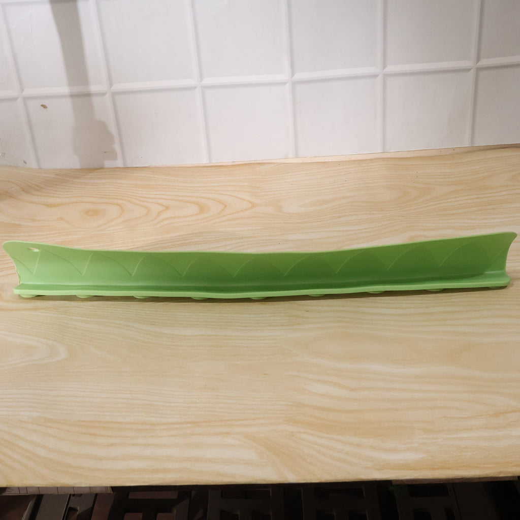 Side angle view of the flexible kitchen sink splash guard on a wooden counter.