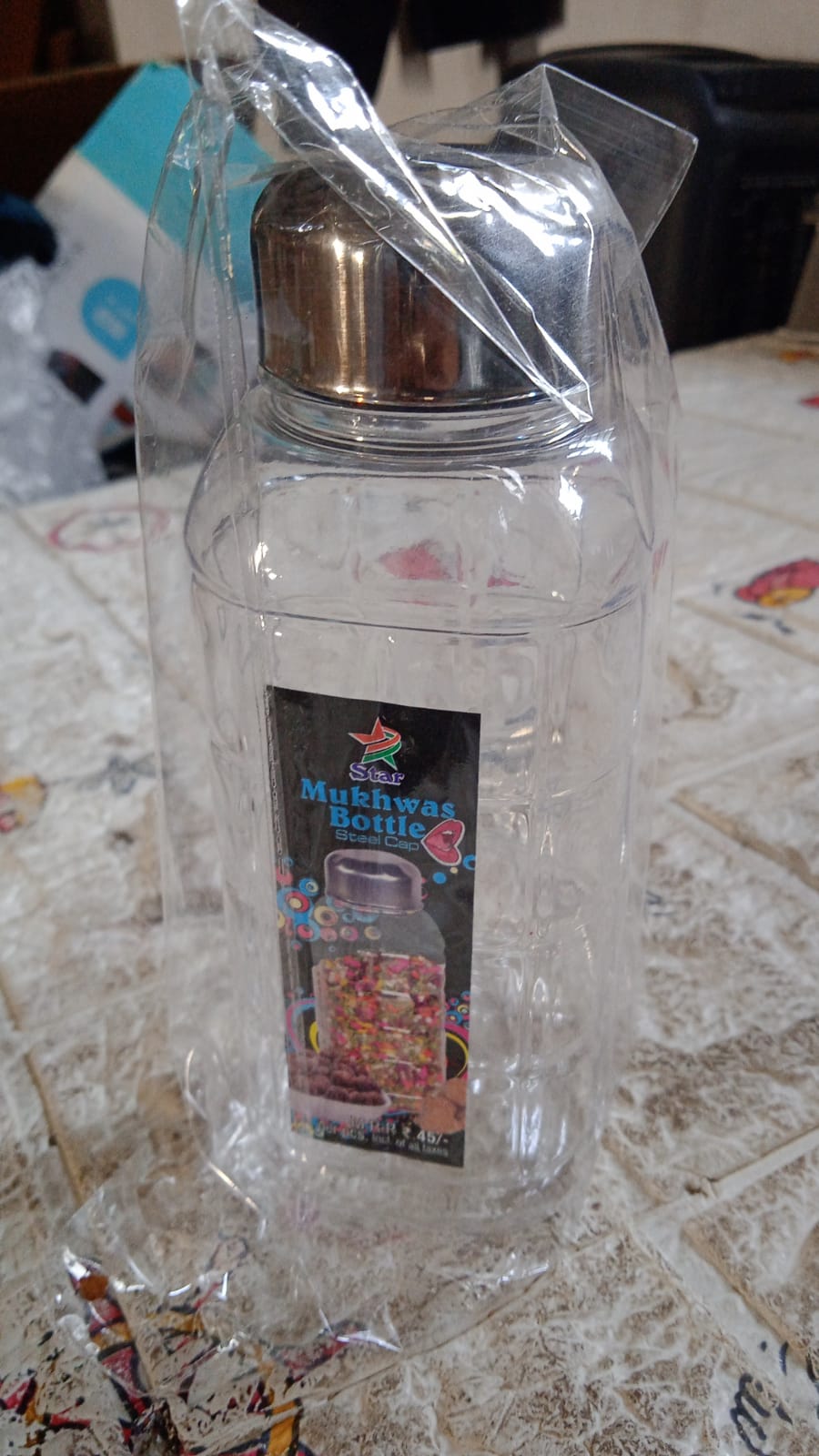 Upright transparent kitchen storage bottle with its steel cap