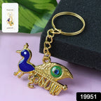 Close-up detail of the golden Krishna Peacock keychain's artistic motif