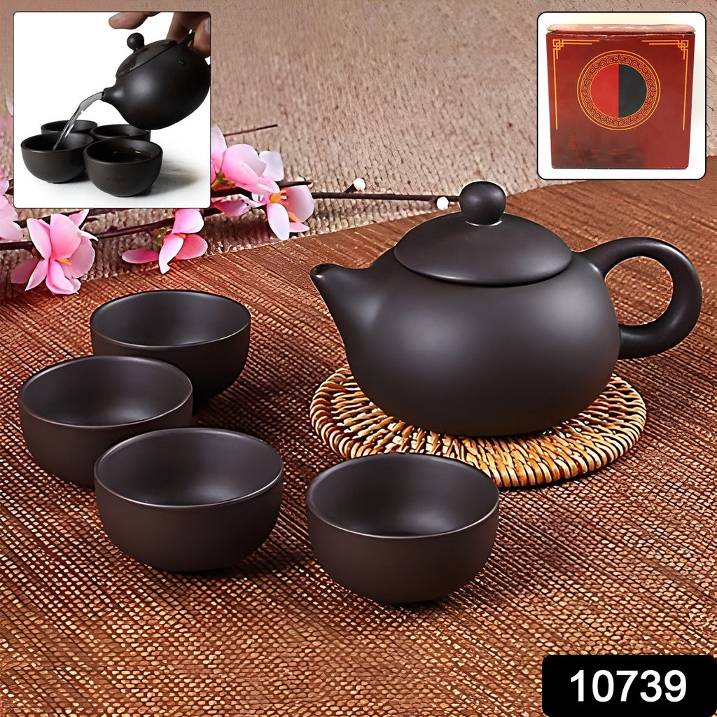 Matte black ceramic teapot alongside four matching ceramic cups
