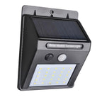 Black solar LED light with motion sensor on a brick wall for outdoor security.