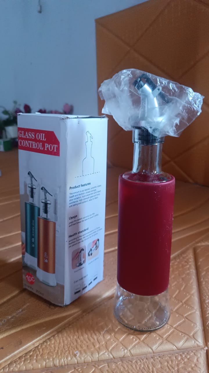 Top view of glass oil dispenser featuring plastic cover and golden pour spout