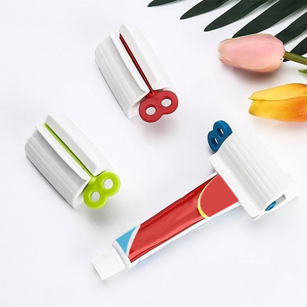 Angled view of the white rolling toothpaste squeezer with a tube, ready for daily use.
