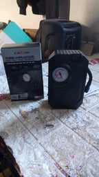 Portable 12V tire inflator kit with all accessories displayed on a clean surface.