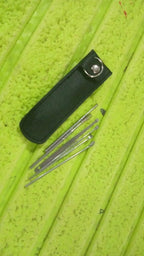 A person safely using a stainless steel ear pick from the reusable ear cleaning tool set.
