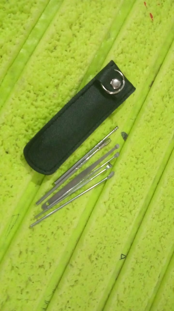 A person safely using a stainless steel ear pick from the reusable ear cleaning tool set.